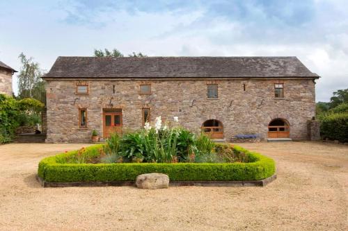 a stone house with a garden in front of it at The Coach House 5 star property in Inistioge