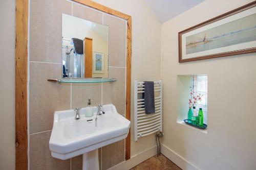 a bathroom with a sink and a mirror at The Coach House 5 star property in Inistioge