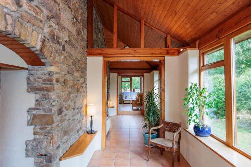 an open hallway with a stone wall and a room with windows at The Coach House 5 star property in Inistioge