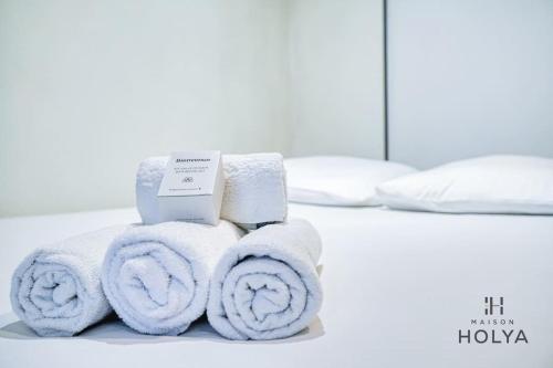 une pile de serviettes posée sur un lit dans l'établissement Le Studieux - À Oberkampf - 82B, à Paris