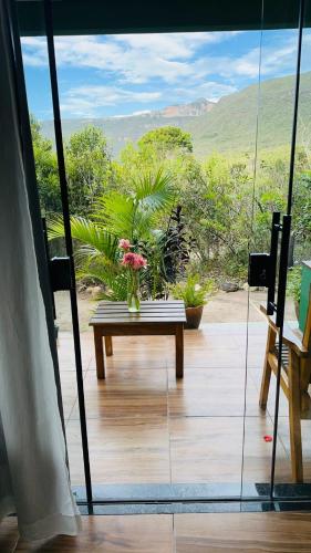 a room with a table and flowers on a balcony at Vila Verde in Palmeiras