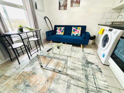 a living room with a blue couch and a washing machine at Chatham hilltop view in Chatham