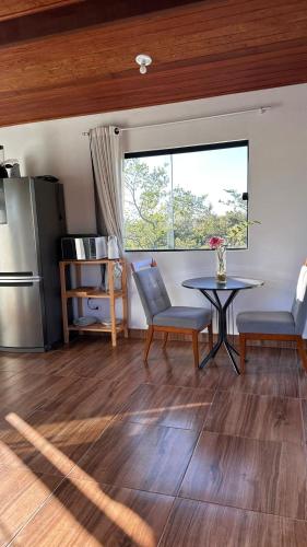 a kitchen with a table and chairs and a window at Vila Verde in Palmeiras