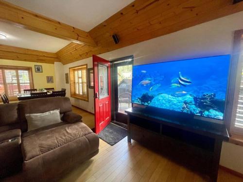 a living room with a large aquarium in the wall at Cabin 7 sleeps 8 BEAUTIFUL BOULDER BAY, BIG BEAR in Big Bear Lake
