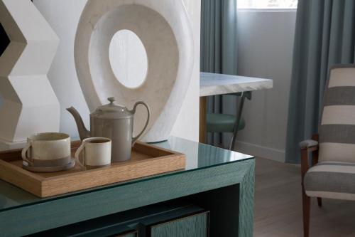 a table with a wooden tray with a tea kettle and a mirror at Avalon Hotel Beverly Hills, a Member of Design Hotels in Los Angeles