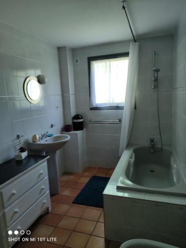 La salle de bains est pourvue d'une baignoire, d'un lavabo et d'une baignoire. dans l'établissement La Périole, à Laurabuc