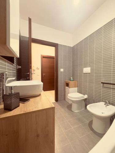a bathroom with a sink and a toilet and a tub and a sink at GC Hejme Locazione Turistica in Lunghezza