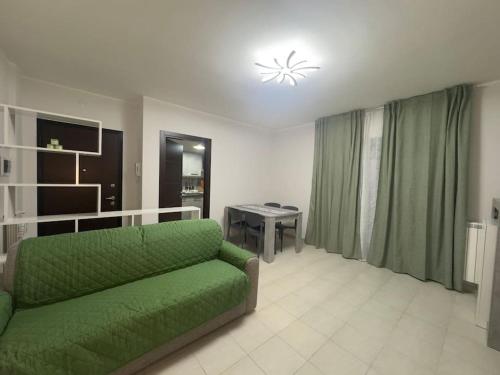 a living room with a green couch and a table at GC Hejme Locazione Turistica in Lunghezza