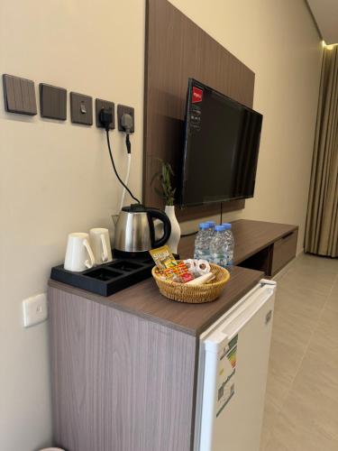 een keuken met een aanrecht met een fornuis en een televisie bij شقق طلال الفندقية- Talal hotel apartments in Al Ula
