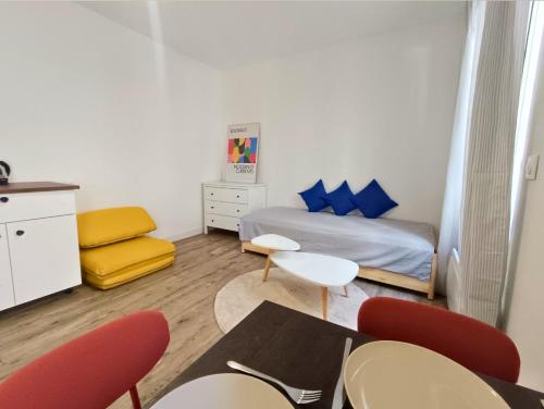 une petite pièce avec un lit, une table et des chaises dans l'établissement Proche de LA VILLETTE - Métro 7 à 1 min, à Pantin