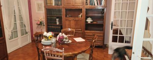 - une salle à manger avec une table et des fleurs dans l'établissement La Genetouze, à La Genétouze