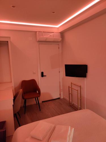 a room with a bed and a chair and a television at Vista Panorâmica Amadora RC in Amadora