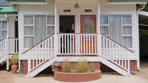 a house with a white porch and a front door at Knock Out View Clarens in Clarens