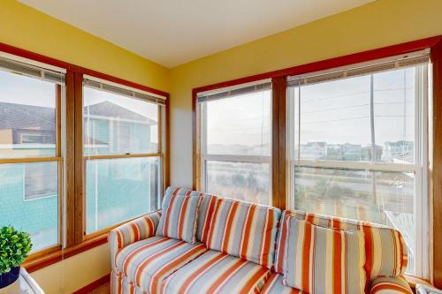 a living room with a couch and three windows at Surfs Inn #35-5 in Avon