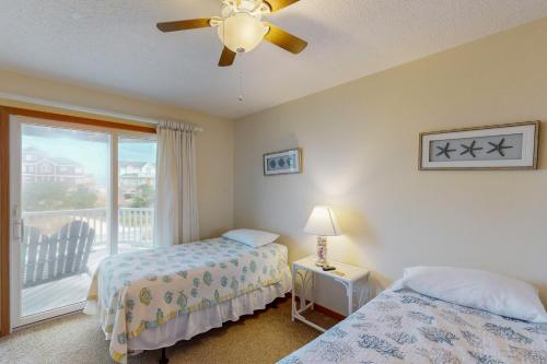 a bedroom with two beds and a balcony at Surfs Inn #35-5 in Avon