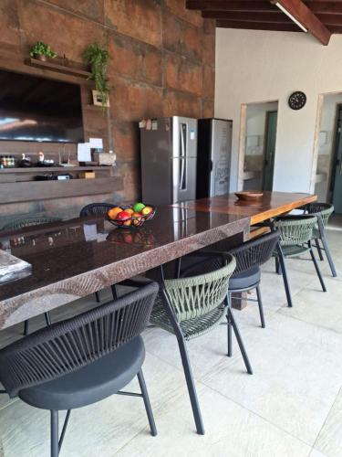 a kitchen with a table with chairs and a refrigerator at Max Suíte in Capitólio