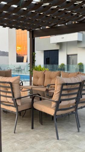 a group of chairs and a glass table on a patio at بيت الشرقية in Mazra‘at Shuway‘ī