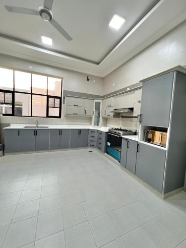 a large kitchen with white cabinets and appliances at بيت الشرقية in Mazra‘at Shuway‘ī
