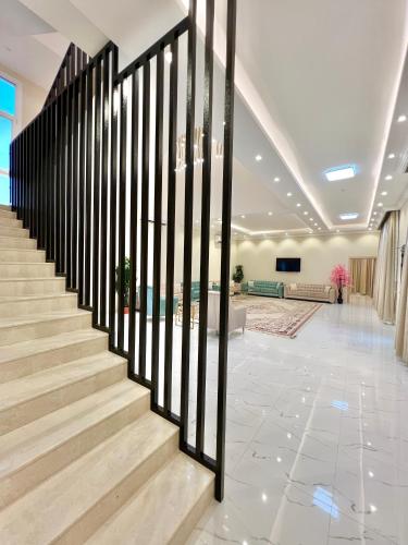 a lobby with a staircase with black railings at بيت الشرقية in Mazra‘at Shuway‘ī