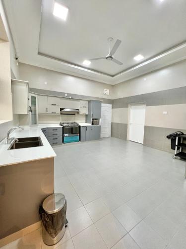 a large kitchen with a large white tile floor at بيت الشرقية in Mazra‘at Shuway‘ī