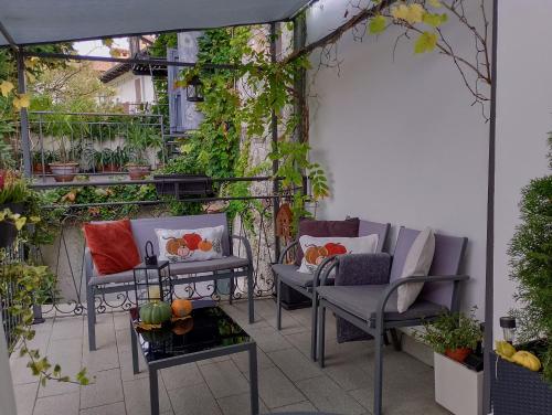 an outdoor patio with chairs and tables and plants at Affittacamere CASA DOLCE CASA SAN DANIELE in San Daniele del Friuli