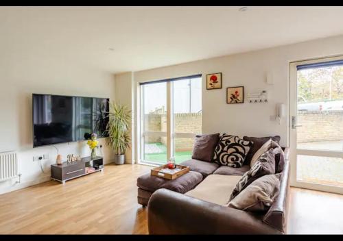 a living room with a couch and a flat screen tv at The Nest of Forest Hill in Forest Hill