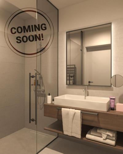 a bathroom with a sink and a mirror with a coming soon sign at Schäfle Feldkirch-Altenstadt in Feldkirch