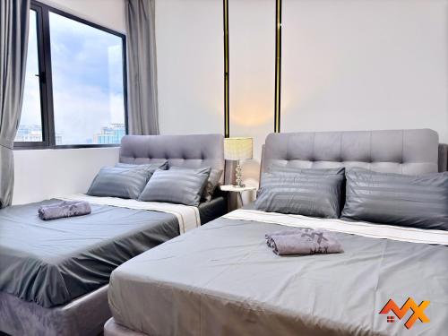two beds sitting next to each other in a room at R&F Mall Princess Cove 10-12pax Sea View-Smart TV 70inch in Johor Bahru