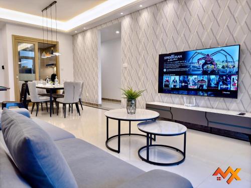 a living room with a couch and tables and a tv at R&F Mall Princess Cove 10-12pax Sea View-Smart TV 70inch in Johor Bahru