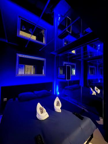 - une chambre bleue avec un lit et des oreillers dans l'établissement love room - Montbéliard, à Montbéliard