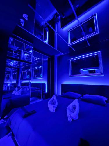 Cette chambre bleue dispose d'un lit avec un éclairage bleu. dans l'établissement love room - Montbéliard, à Montbéliard