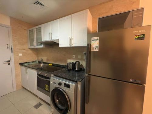a kitchen with a stainless steel refrigerator and a dishwasher at Stylish Studio With Amazing View in Dubai