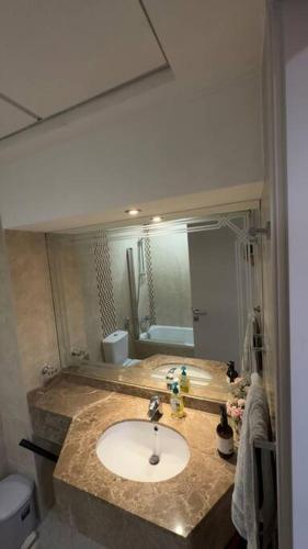 a bathroom with a sink and a large mirror at Stylish Studio With Amazing View in Dubai