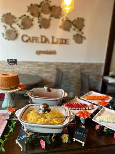 a table topped with cakes and food on top at Pousada da Leide in Fernando de Noronha