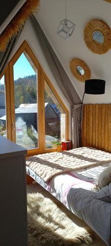 a bedroom with a bed and a large window at Lux Houses w DOMKU tylko DWA APARTAMENTYz jacuzzi zewnętrznym in Groń