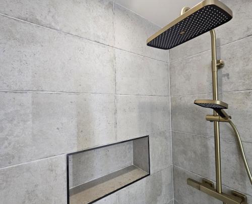 d'une douche avec un grand mur en carrelage et un éclairage. dans l'établissement Chic Apartment By Capucine - Grands Magasins, à Paris