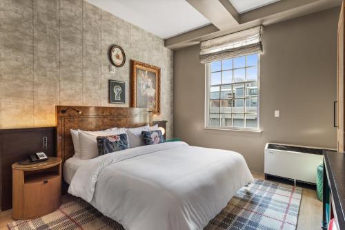 a bedroom with a large white bed and a window at Hotel Indigo Baton Rouge Downtown by IHG in Baton Rouge