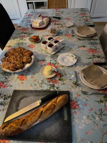 a table with a knife and plates of food on it at Les glycines in Bonneval