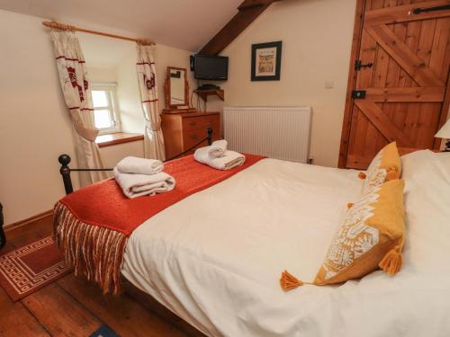 a bedroom with a bed with towels on it at Ty Siabod in Betws-y-coed