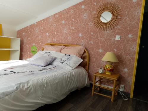 Schlafzimmer mit einem Bett und einem Spiegel an der Wand in der Unterkunft charmante maisonnette au calme in Montélimar