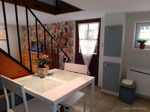 une salle à manger avec une table et des chaises blanches dans l'établissement charmante maisonnette au calme, à Montélimar