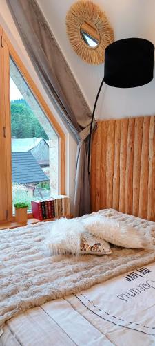 a bedroom with a large bed with a large window at Lux Houses w DOMKU tylko DWA APARTAMENTYz jacuzzi zewnętrznym in Groń