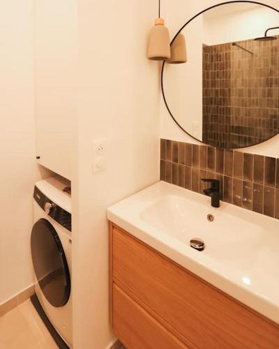 une salle de bain avec un lavabo et une machine à laver dans l'établissement Longchamp - 2 chambres avec Terrasse - Wifi - Clim, à Marseille