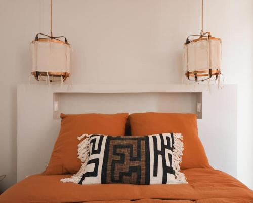 - un lit orange avec deux lumières au-dessus dans l'établissement Longchamp - 2 chambres avec Terrasse - Wifi - Clim, à Marseille