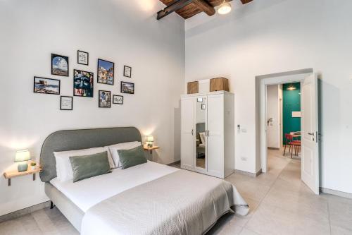 a bedroom with a white bed and pictures on the wall at NextStopPignasecca in Naples
