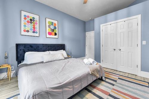 a bedroom with a large bed with blue walls at Modern Midtown 1B Apartment King Bed and Smart TVs in Omaha