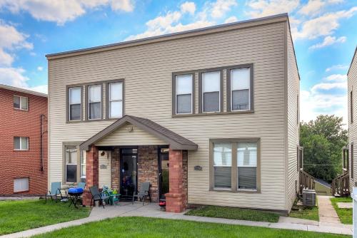 a large house with a porch with tables and chairs at Modern Midtown 1B Apartment King Bed and Smart TVs in Omaha