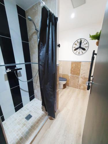 La salle de bains est pourvue d'une douche avec rideau de douche noir. dans l'établissement Grand gîte Touraine 300m2, à La Membrolle-sur-Choisille