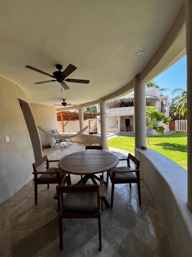 a patio with a table and chairs and a ceiling fan at Villas Cononda in La Majahua