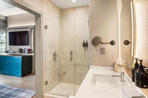 a bathroom with a shower and a sink at Hotel Indigo Baton Rouge Downtown by IHG in Baton Rouge